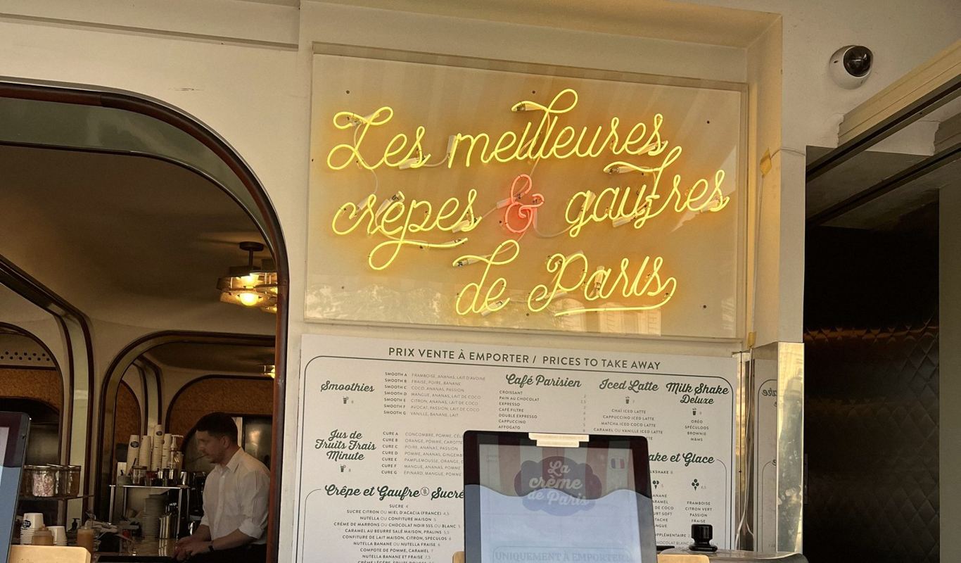 A warm Paris café advertising the best crêpes and gaufres — a cosy rainy-day stop