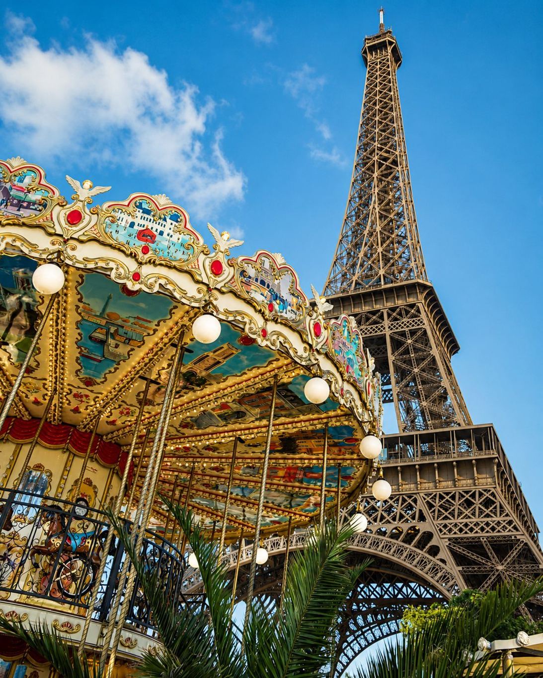A vintage double-decker carousel turning beneath the Eiffel Tower in Paris