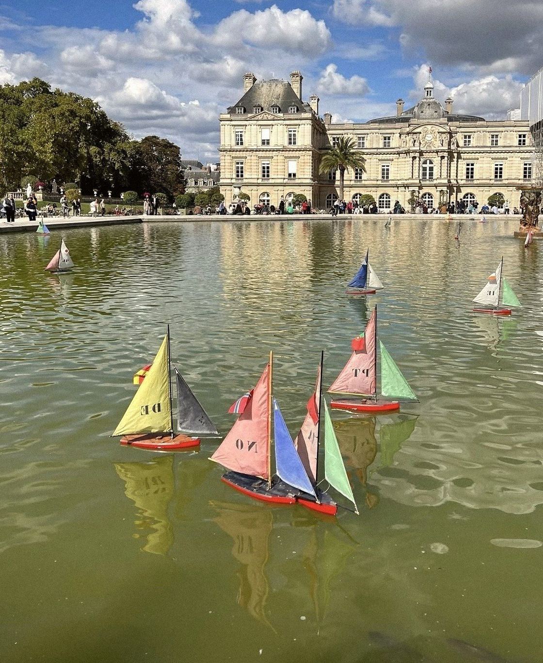 Wooden toy sailboats on the Grand Bassin pond in front of the Luxembourg Palace, Jardin du Luxembourg, Paris