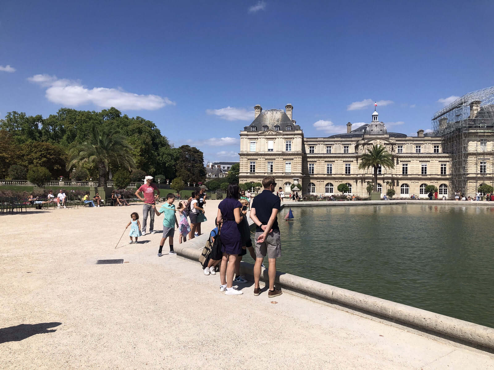 The Luxembourg Palace and the Grand Bassin pond with families and a toy sailboat, Jardin du Luxembourg, Paris