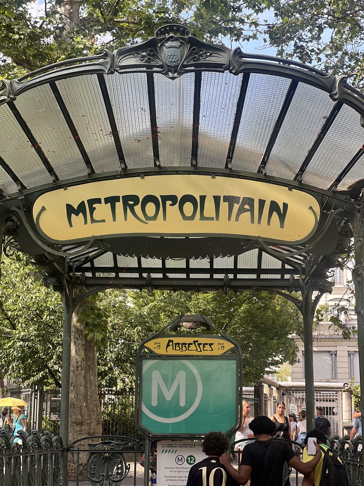 The Art Nouveau glass canopy of the Abbesses métro entrance with the green Métropolitain sign