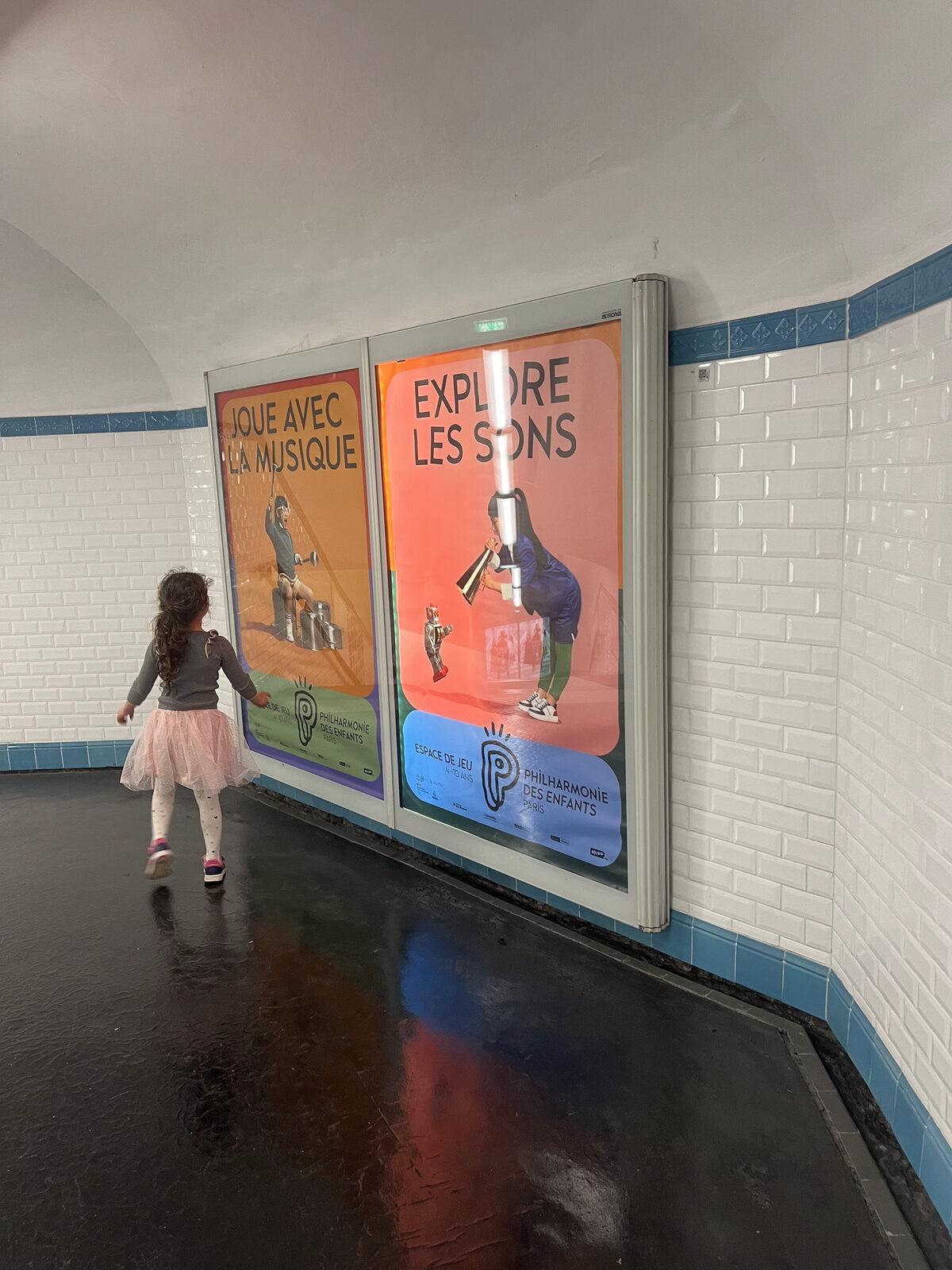 A child looking at posters in a Paris métro station