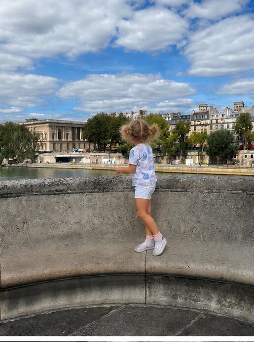 A child running and playing by a fountain in a Paris garden