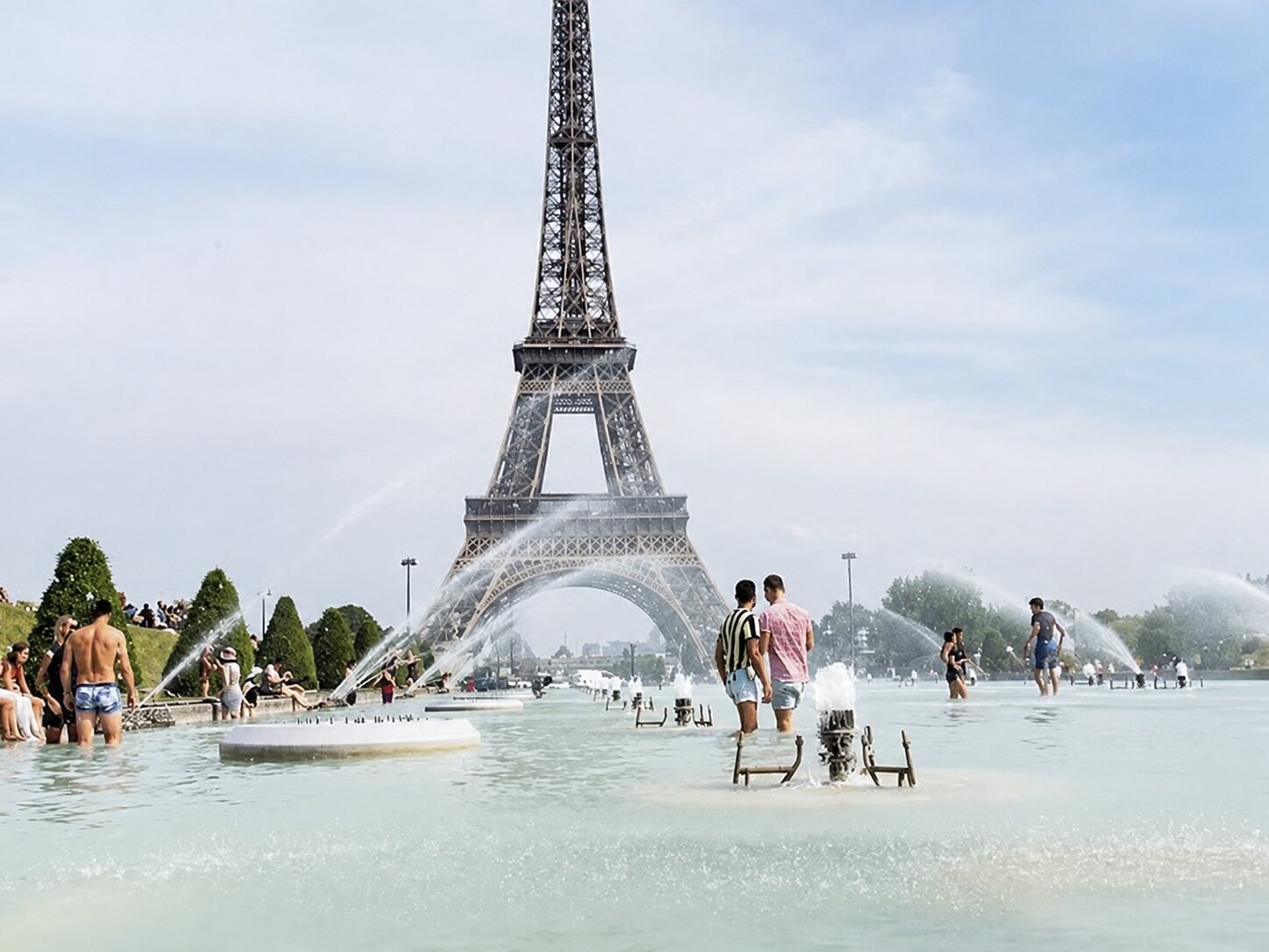 People cooling off in the Trocadéro fountains in front of the Eiffel Tower during a Paris heatwave